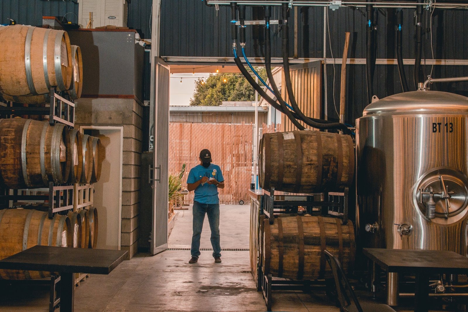 Ollie team member walking a row of barrels at the brewery