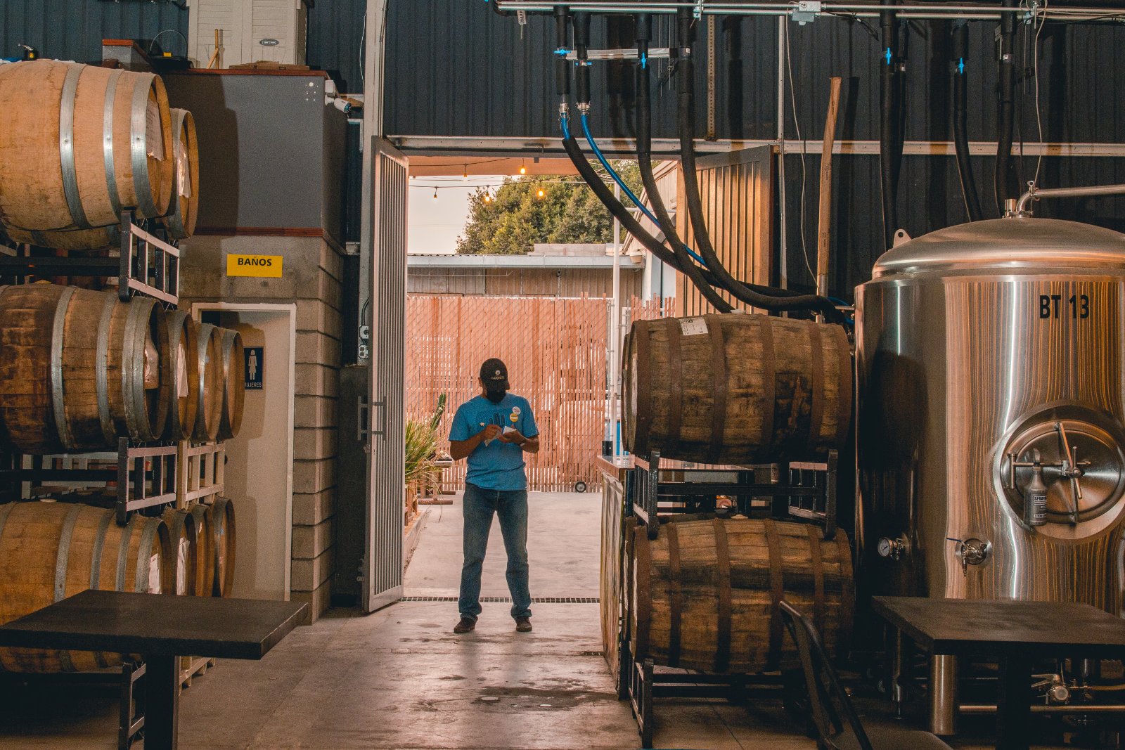 Ollie team member walking a row of barrels at the brewery