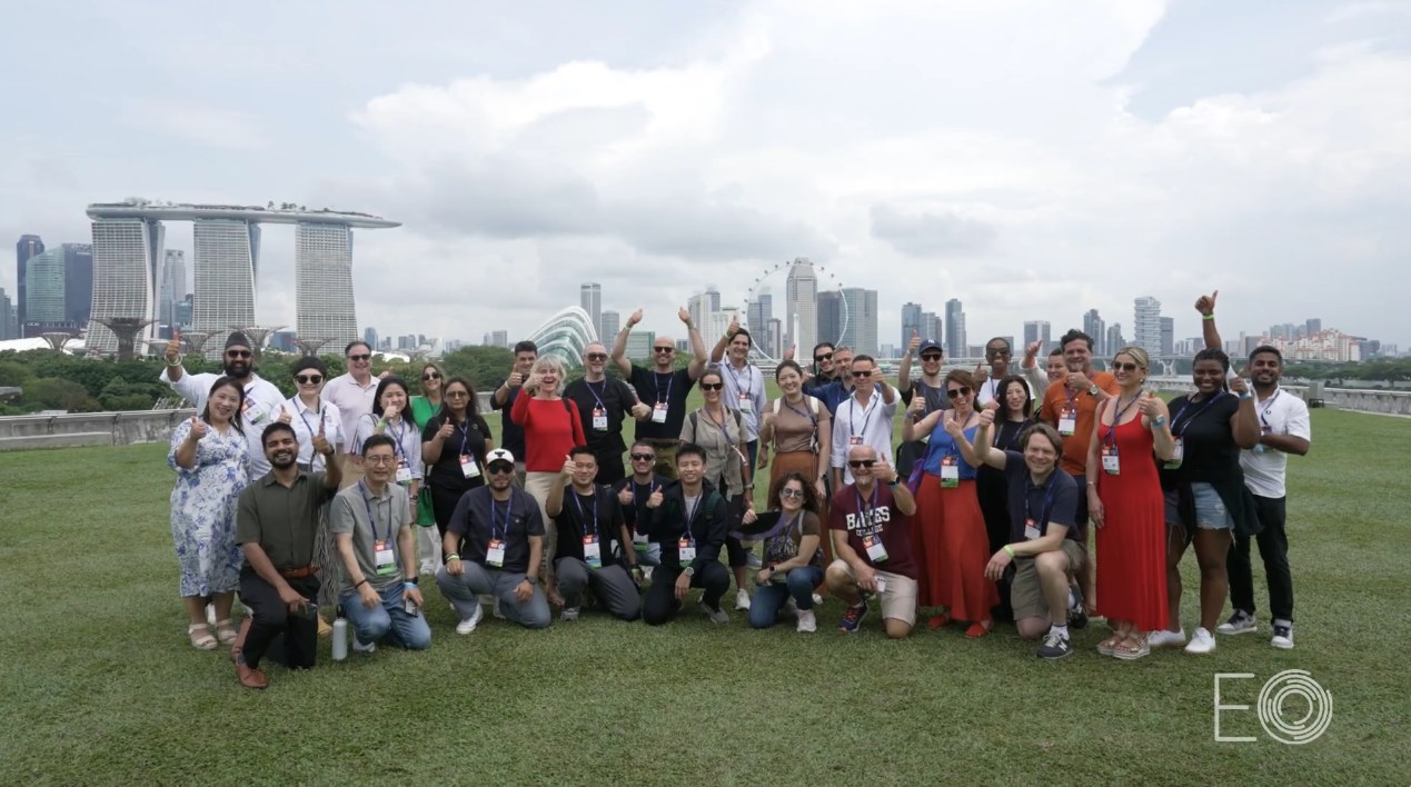 GLC 2024 attendees on a rooftop overlooking the Singapore skyline, Marina Bay Sands and Gardens by the Bay in the distance