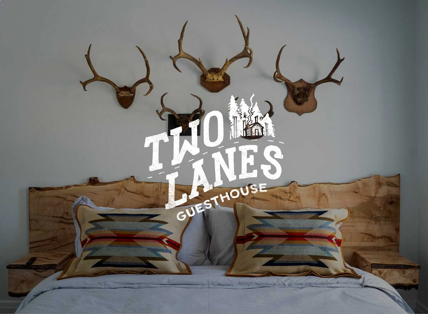 Two Lanes Guesthouse bedroom, live-edge headboard and antler wall display