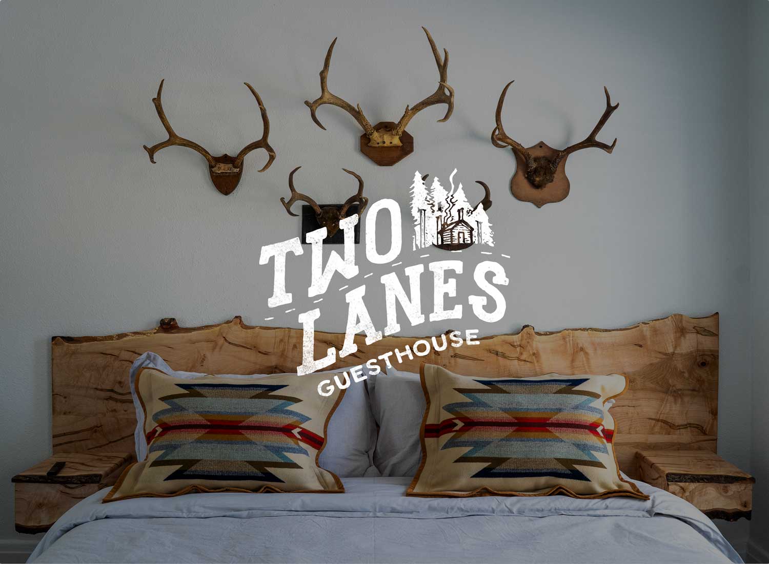 Two Lanes Guesthouse bedroom interior with antlers and a live-edge wood headboard